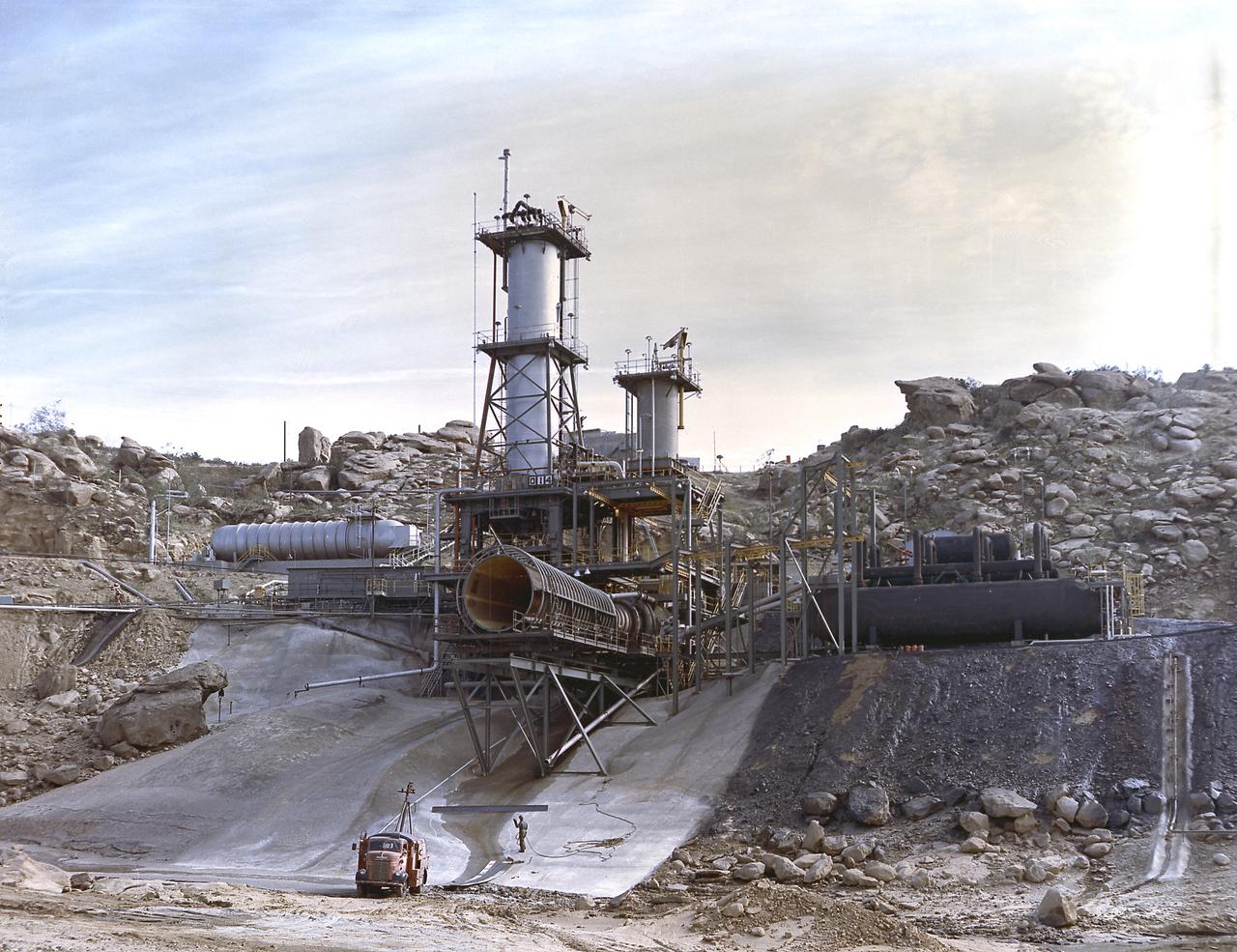 This image depicts an overall view of the vertical test stand for testing the J-2 engine at Rocketdyne's Propulsion Field Laboratory, in the Santa Susana Mountains, near Canoga Park, California. The J-2 engines were assembled and tested at Rocketdyne under the direction of the Marshall Space Flight Center. 