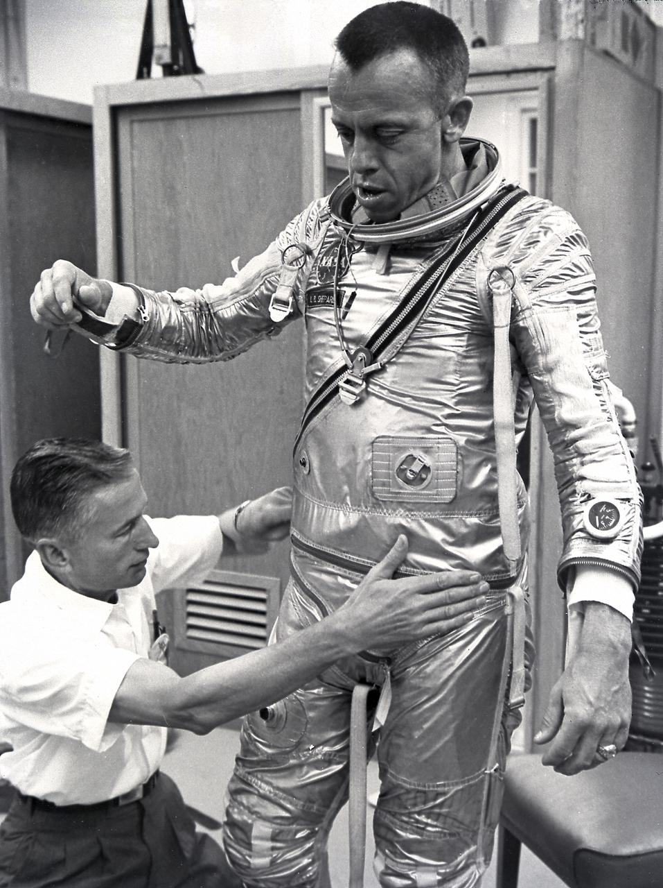 Astronaut Alan Shepard fitted with space suit prior to the first marned suborbital flight. Freedom 7, carrying Astronaut Alan Shepard, boosted by the Mercury-Redstone launch vehicle, lifted off on May 5, 1961. Astronaut Shepard became the first American in space. 