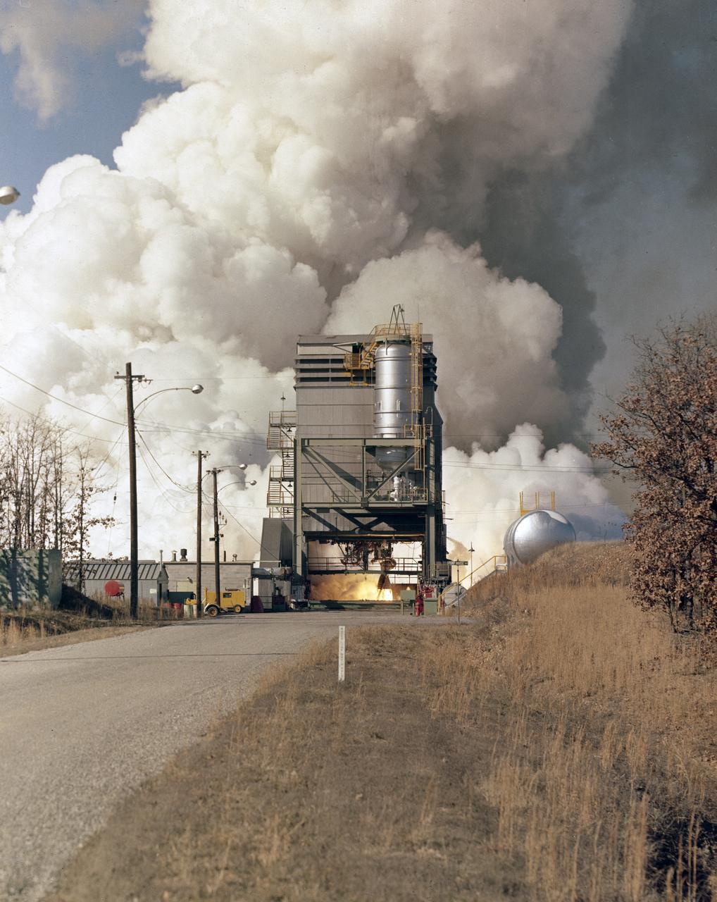 In this photograph, the single H-1 engine was test-fired at Canoga Park, California. Initial development of testing for the H-1 engine took place in the engineering facilities at Rocketdyne's main plant in Canoga Park, California.