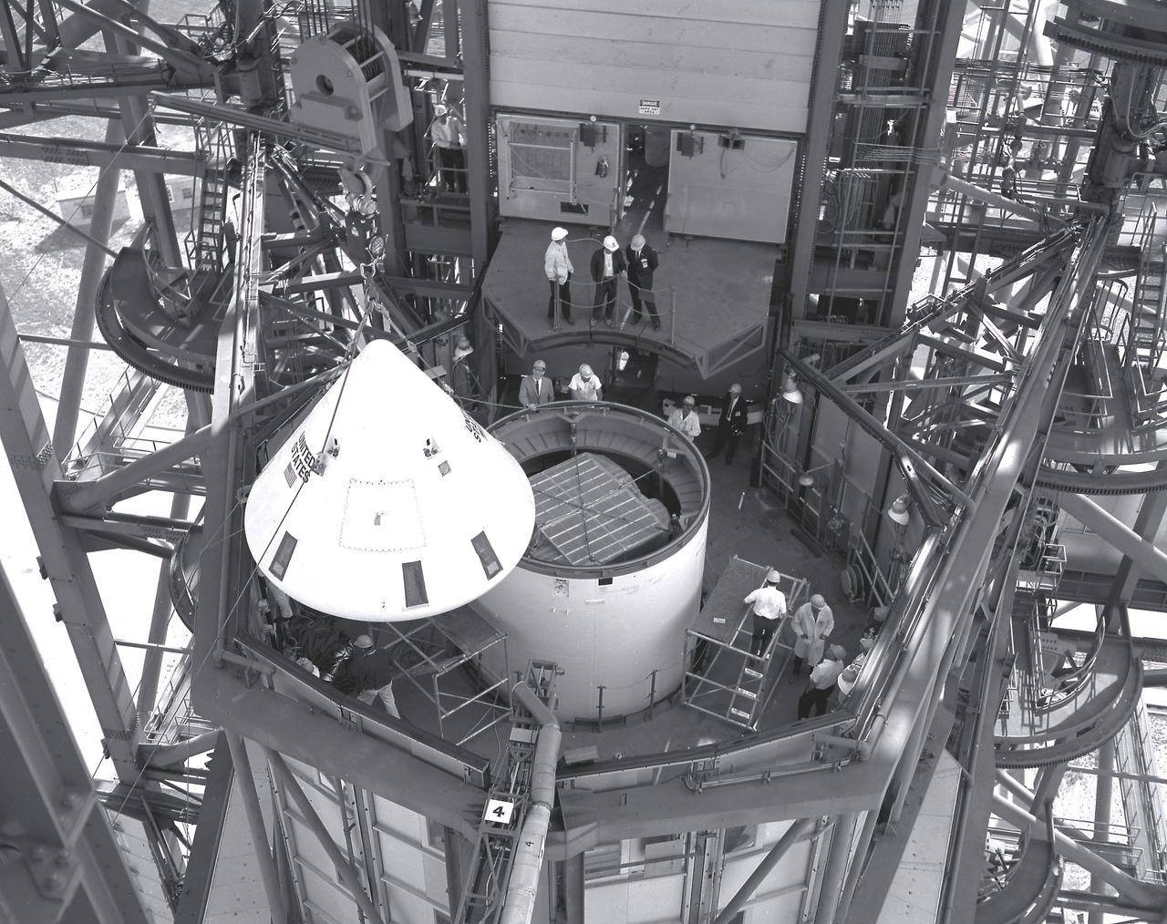 In this photograph, the Pegasus, meteoroid detection satellite is installed in its specially modified Apollo service module atop the S-IV stage (second stage) of a Saturn I vehicle for the SA-9 mission at Cape Kennedy. Personnel in the service structure moved the boilerplate Apollo command module into place to cap the vehicle. The command and service modules, visible here, were jettisoned into orbit to free the Pegasus for wing deployment. The satellite was used to obtain data on frequency and penetration of the potentially hazardous micrometeoroids in low Earth orbits and to relay the information back to Earth. The SA-9 was launched on February 16, 1965.