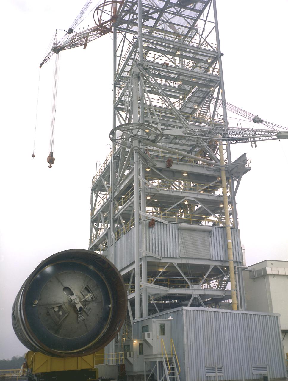Workers at the Marshall Space Flight Center (MSFC) move a facility test version of the Saturn IB launch vehicle's second stage, the S-IVB, to the J-2 test stand on February 10, 1965. Also known as a "battleship" because of its heavy, rugged construction, the non-flight, stainless-steel model was used to check out testing facilities at MSFC.