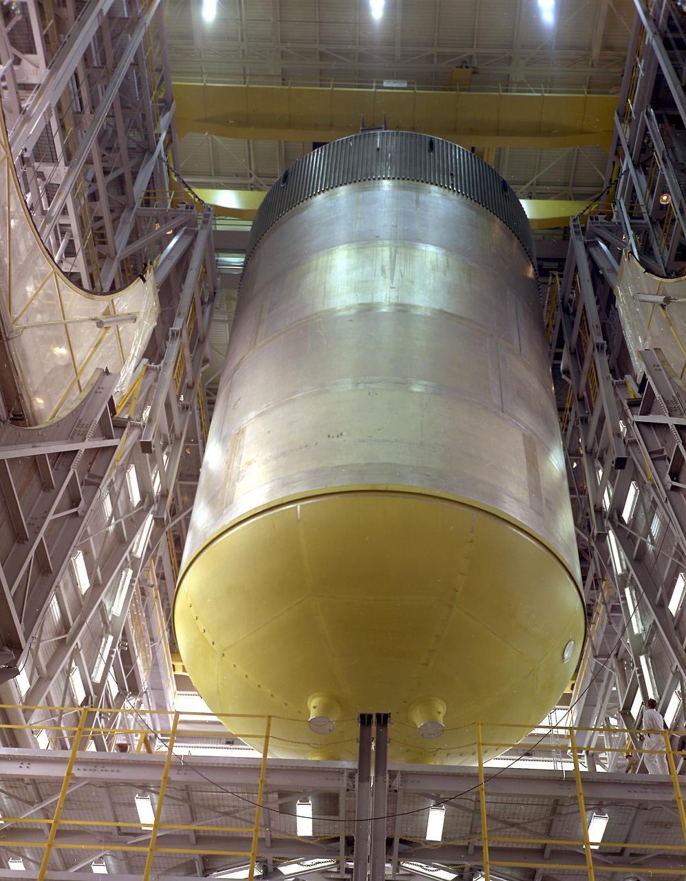 This photograph shows the Saturn V S-IC-S stage (S-IC stage for structural test) liquid oxygen (LOX) tank being lifted in the vehicle assembly building at the Marshall Space Flight Center.