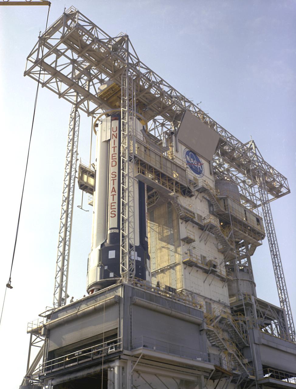 S-IB-1, the first flight version of the Saturn IB launch vehicle's first stage (S-IB stage), sat in the Marshall Space Flight Center (MSFC) Saturn IB static test stand on March 15, 1965. Developed by the MSFC and built by the Chrysler Corporation at the Michoud Assembly Facility (MAF) in New Orleans, Louisiana, the 90,000-pound booster utilized eight H-1 engines to produce a combined thrust of 1,600,000 pounds.