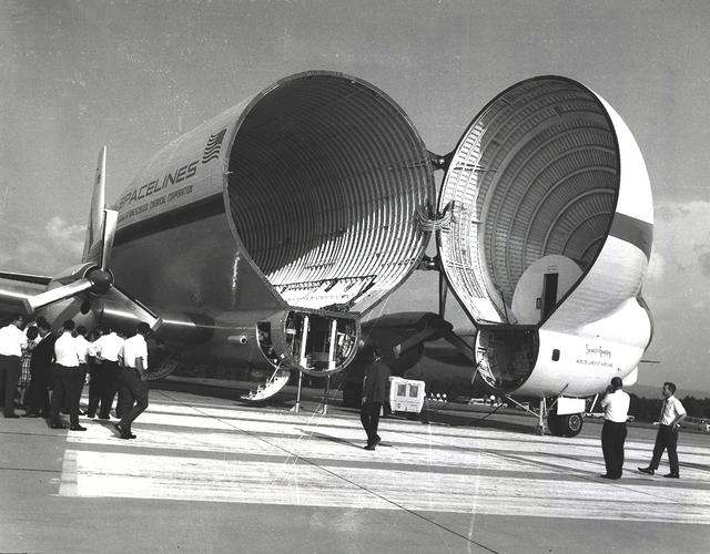 The Super Guppy is shown at the Redstone Airstrip. NASA used the aircraft to transport the S-IVB upper stage used on the Saturn IB and Saturn V launch vehicles between manufacturing facilities on the West coast, and testing and launch facilities in the Southeast. This aircraft was built by John M. Conroy of Aero Spaceliners, Incorporated, who started with the fuselages of a surplus Boeing C-97 Stratocruiser, ballooned out the upper decks enormously, and hinged the front sections so that they could be folded back 110 degrees. The Super Guppy flew smoothly at a 250-mph cruising speed, and its cargo deck provided a 25-foot clear diameter.