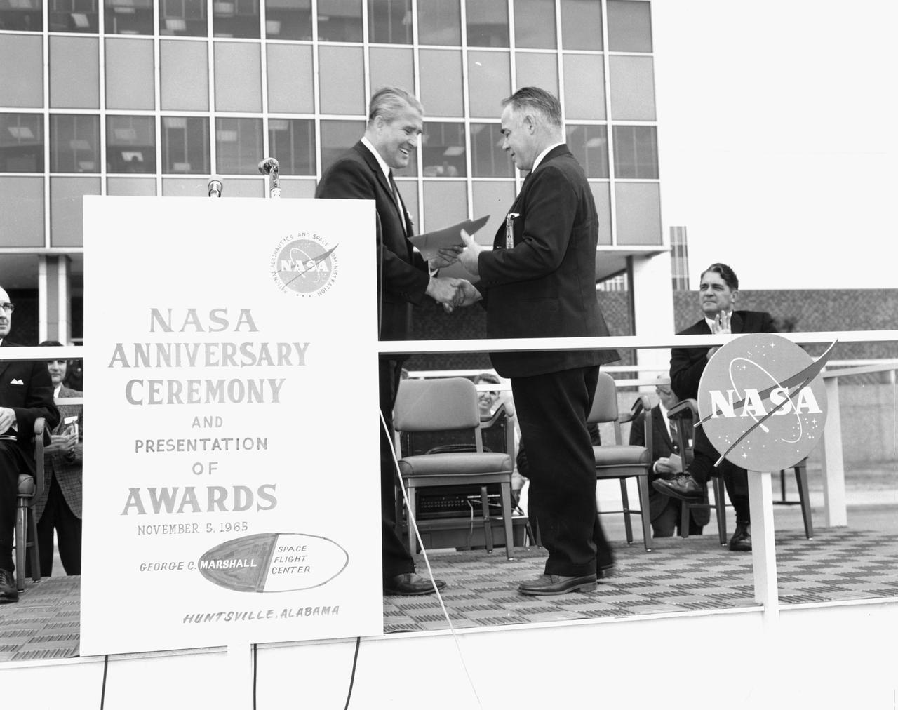 In this photograph, Marshall Space Flight Center Director, Dr. Wernher von Braun, presents a Co-Inventor’s award to MSFC employee Martin Hall of the Mechanical Engineering Laboratory  during the NASA Anniversary ceremony.