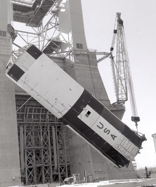 This vintage photograph shows the 138-foot long first stage of the Saturn V being lowered to the ground following a successful static test firing at Marshall Space flight Center's S-1C test stand. The firing provided NASA engineers information on the booster's systems. The towering 363-foot Saturn V was a multi-stage, multi-engine launch vehicle standing taller than the Statue of Liberty. Altogether, the Saturn V engines produced as much power as 85 Hoover Dams.