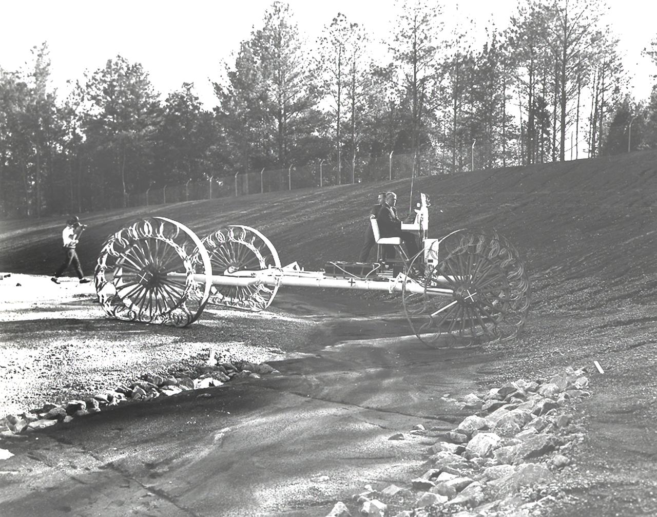 In this June, 1966 photograph, Marshall Space Flight Center Director, Dr. Wernher von Braun test drives the Mobility Test Article (MTA), a developmental vehicle built by the Bendix Corporation to test lunar mobility concepts. The data provided by the MTA helped in designing the Lunar Roving Vehicle (LRV), developed under the direction of the Marshall Space Flight Center. The LRV was designed to allow Apollo astronauts a greater range during lunar exploration missions and served its purpose during the last three Apollo lunar missions in 1971 and 1972.