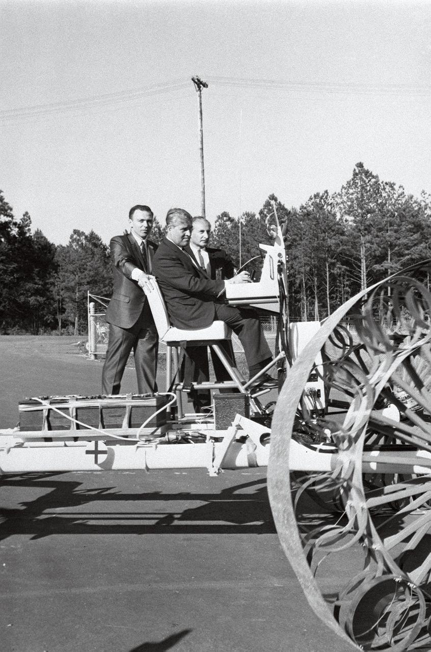 In this June 1966 photograph, Marshall Space Flight Center Director Dr. Wernher von Braun test-drives the Mobility Test Article (MTA), a developmental vehicle built by the Bendix Corporation to test lunar mobility vehicle concepts. The data provided by the MTA helped in designing the Lunar Roving Vehicle (LRV), developed under the direction of the MSFC. The LRV was designed to allow Apollo astronauts a greater range of mobility during lunar exploration missions. The LRVs were deployed during the last three Apollo missions; Apollo 15, Apollo 16, and Apollo 17. 
