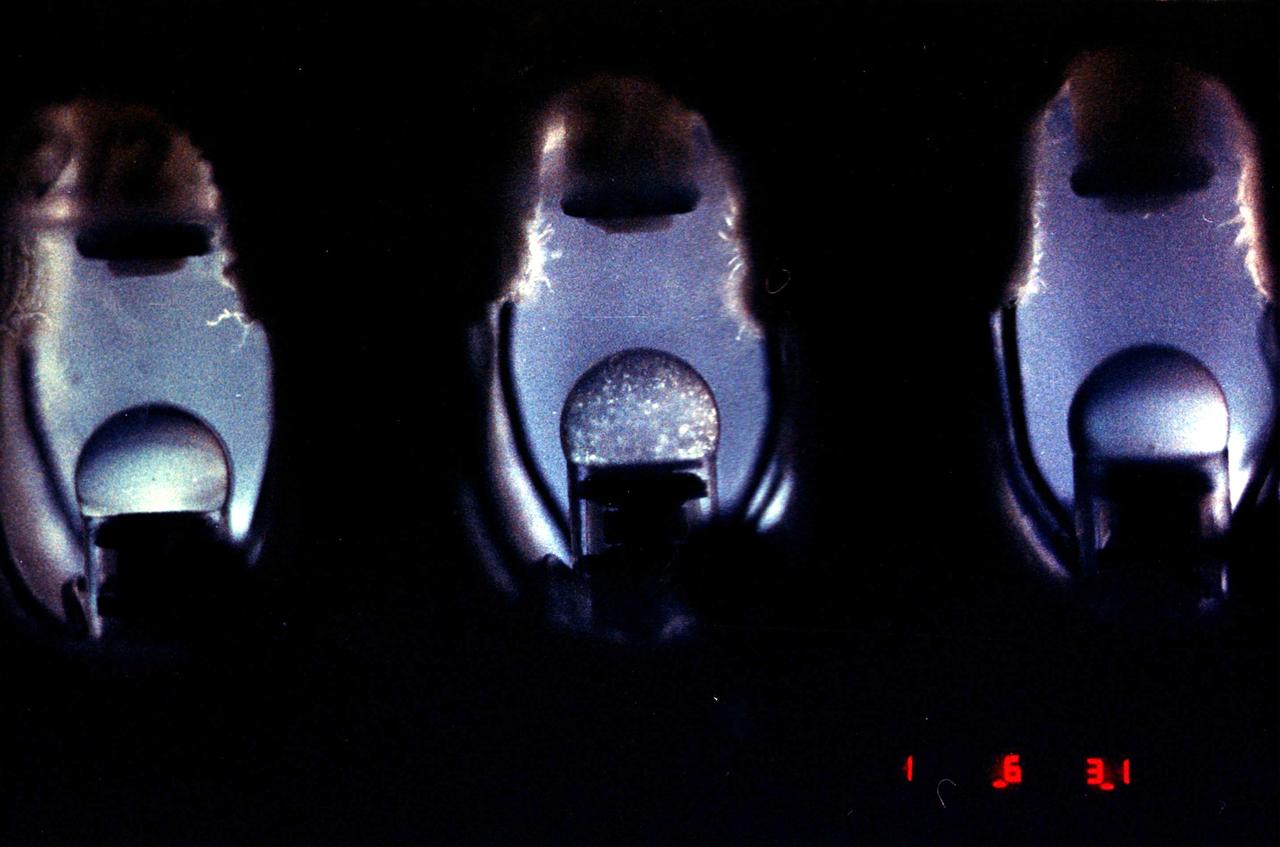Crystals grown in the hand-held Protein Crystallization Apparatus for Microgravity (PCAM) onboard STS-61C. The PCAM has a pedestal in the center of a circular chamber, the surrounding chamber holds an absorbent reservoir that contains a solution of the precipitant. Vapor pressure differences between the protein solution and the reservoir solution force water to move from the protein solution to the reservoir. As protein concentrations increase, protein crystals begin to nucleate and grow.