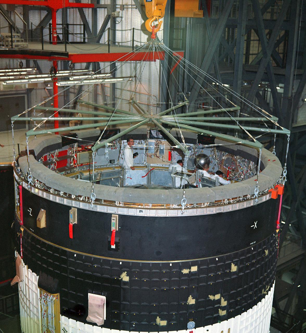This photograph was taken during the final assembly operation of the Saturn V launch vehicle for the Apollo 4 (SA 501) mission. The instrument unit (IU) was mated atop the S-IC/S-II assembly in the Vehicle Assembly Building high bay at the Kennedy Space Center. The Apollo 4 mission was the first launch of the Saturn V launch vehicle. Objectives of the unmanned Apollo 4 test flight were to obtain flight information on launch vehicle and spacecraft structural integrity and compatibility, flight loads, stage separation, and subsystems operation including testing of restart of the S-IVB stage, and to evaluate the Apollo command module heat shield. The Apollo 4 was launched on November 9, 1967 from KSC. 