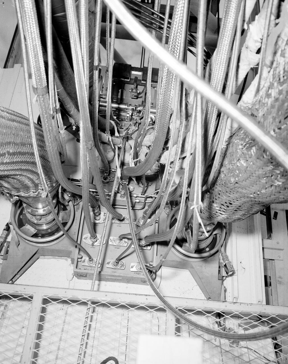 The Marshall Space Flight Center (MSFC) played a crucial role in the development of the huge Saturn rockets that delivered humans to the moon in the 1960s.  Many unique facilities existed at MSFC for the development and testing of the Saturn rockets.  Affectionately nicknamed “The Arm Farm”, the Random Motion/ liftoff Simulator was one of those unique facilities. This facility was developed to test the swing arm mechanisms that were used to hold the rocket in position until liftoff. The Arm Farm provided the capability of testing the detachment and reconnection of various arms under brutally realistic conditions.  The 18-acre facility consisted of more than a half dozen arm test positions and one position for testing access arms used by the Apollo astronauts. Each test position had two elements: a vehicle simulator for duplicating motions during countdown and launch; and a section duplicating the launch tower. The vehicle simulator duplicated the portion of the vehicle skin that contained the umbilical connections and personnel access hatches. Driven by a hydraulic servo system, the vehicle simulator produced relative motion between the vehicle and tower. On the Arm Farm, extreme environmental conditions (such as a launch scrub during an approaching Florida thunderstorm) could be simulated. The dramatic scenes that the Marshall engineers and technicians created at the Arm Farm permitted the gathering of crucial technical and engineering data to ensure a successful real time launch from the Kennedy Space Center. This photo depicts a general view of the S-IV-B aft swing arm umbilical carrier line tray modification.