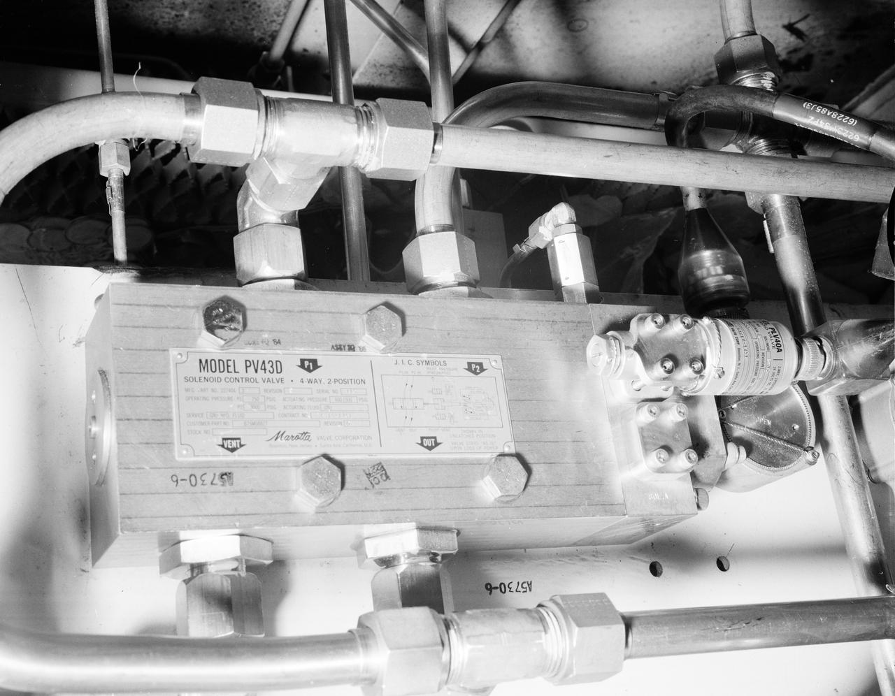 The Marshall Space Flight Center (MSFC) played a crucial role in the development of the huge Saturn rockets that delivered humans to the moon in the 1960s.  Many unique facilities existed at MSFC for the development and testing of the Saturn rockets.  Affectionately nicknamed “The Arm Farm”, the Random Motion/ liftoff Simulator was one of those unique facilities. This facility was developed to test the swing arm mechanisms that were used to hold the rocket in position until liftoff. The Arm Farm provided the capability of testing the detachment and reconnection of various arms under brutally realistic conditions.  The 18-acre facility consisted of more than a half dozen arm test positions and one position for testing access arms used by the Apollo astronauts. Each test position had two elements: a vehicle simulator for duplicating motions during countdown and launch; and a section duplicating the launch tower. The vehicle simulator duplicated the portion of the vehicle skin that contained the umbilical connections and personnel access hatches. Driven by a hydraulic servo system, the vehicle simulator produced relative motion between the vehicle and tower. On the Arm Farm, extreme environmental conditions (such as a launch scrub during an approaching Florida thunderstorm) could be simulated. The dramatic scenes that the Marshall engineers and technicians created at the Arm Farm permitted the gathering of crucial technical and engineering data to ensure a successful real time launch from the Kennedy Space Center. This photo depicts a close up of the S-IV-B aft swing arm orifice on the PV 43D soloniod valve.