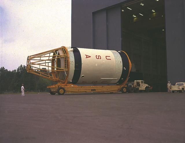This September 1967 photograph shows workmen removing a mockup of the Saturn V S-IVB stage that housed the Skylab Orbital Workshop (OWS) from the Marshall Space Flight Center (MSFC), building 4755. The mockup was shipped to McDornell Douglas in Huntington, California for design modifications. NASA used the mockup as an engineering design tool to plan structures, equipment, and experiments for Skylab, an orbiting space laboratory. The MSFC had program management responsibility for the development of Skylab hardware and experiments, including the OWS.