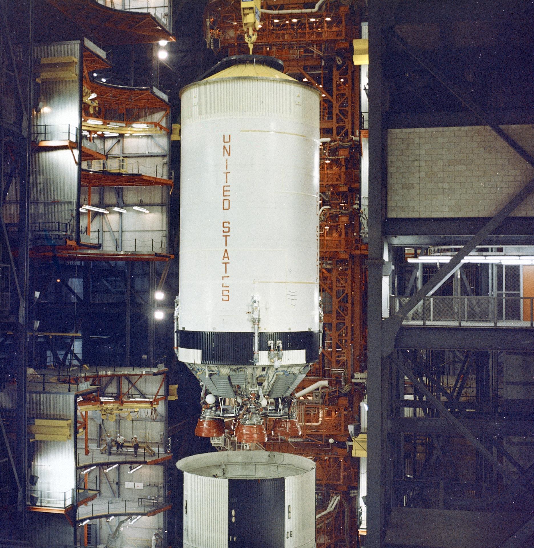 Saturn V second stage being lowered into place during assembly of Apollo 6 vehicle