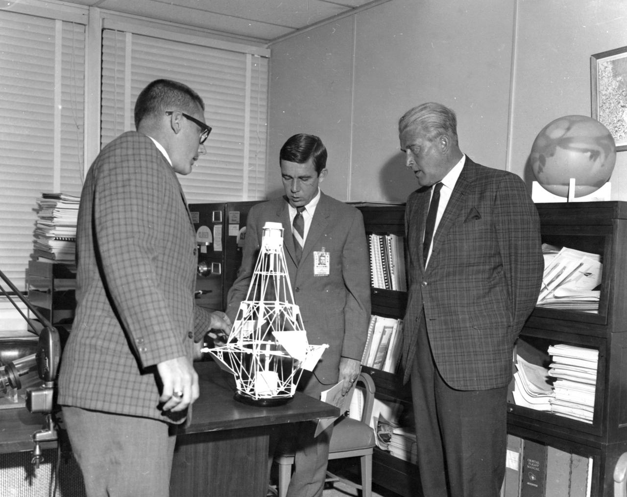 Dr. Wernher von Braun, Director of the Marshall Space Flight Center (right), listens to an explanation of an advanced orbiting observatory concept from MSFC employees Ted Carey, Vehicle and Mission Analysis Office (left), and Frank Williams, Director of Advanced Systems Office.