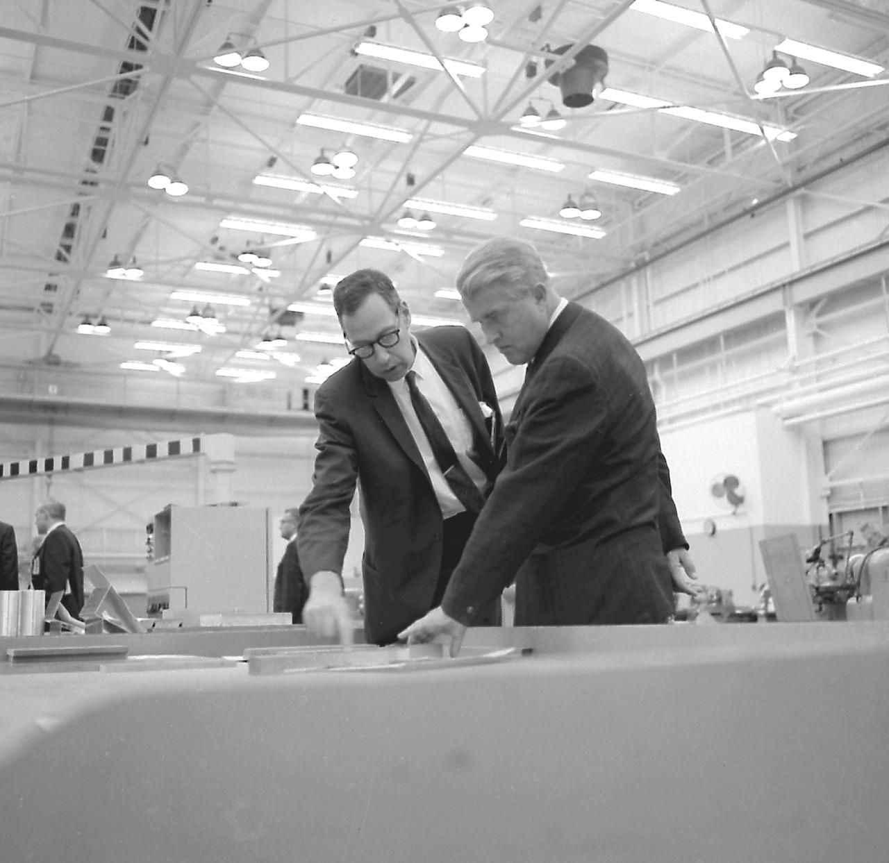 Dr. von Braun, Director of the Marshall Space Flight Center, listens attentively to a briefing on the metal forming techniques by Dr. Mathias Siebel of the Manufacturing and Engineering Laboratory at MSFC on October 17, 1967.