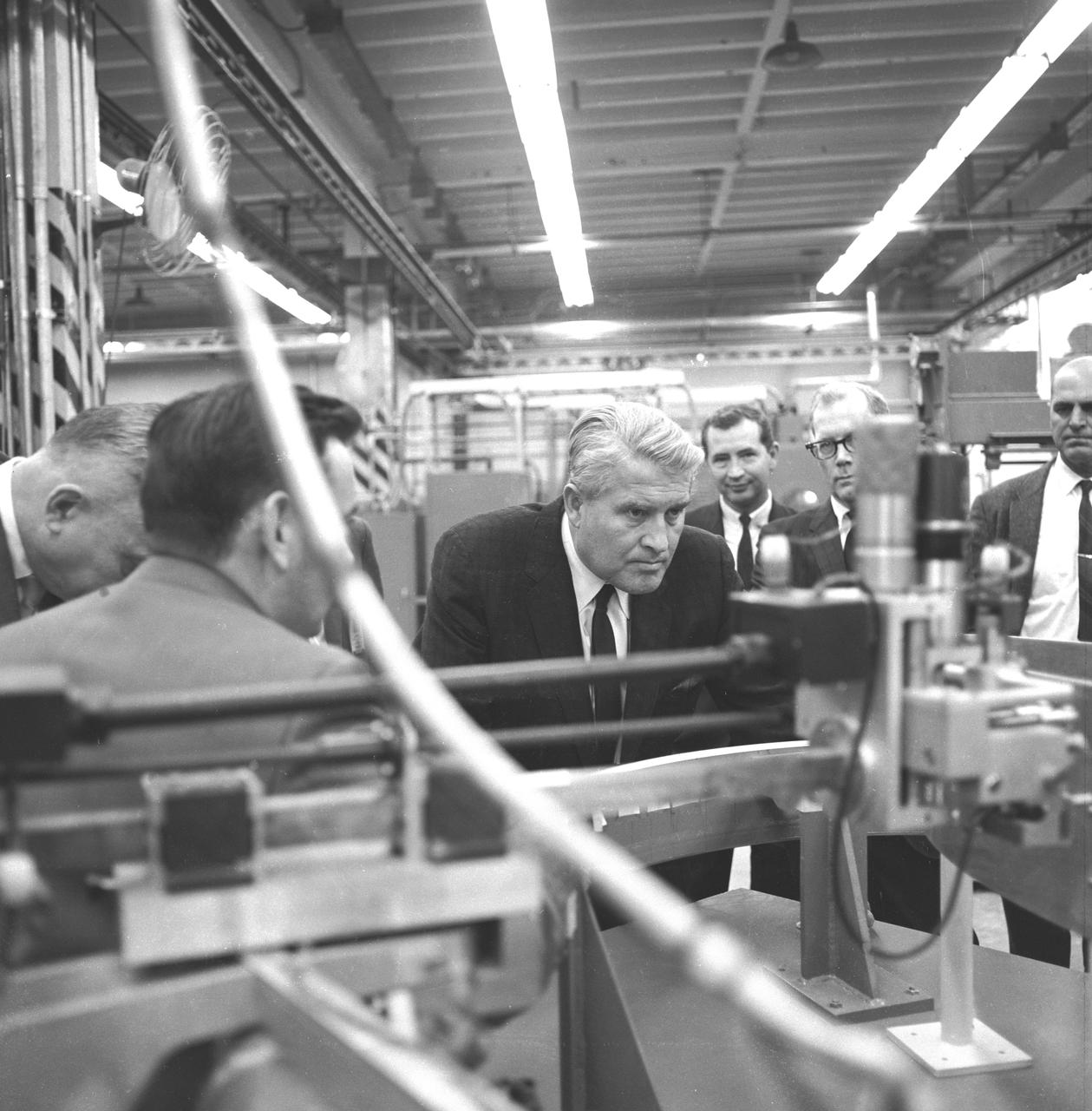 Dr. von Braun examining a welding device during the tour of the MSFC Manufacturing and Engineering (ME) Laboratory on October 17, 1967. 