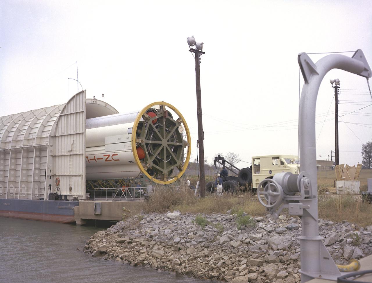 Workmen at the Marshall Space Flight Center's (MSFC's) dock on the Ternessee River unload S-IB-211, the flight version of the Saturn IB launch vehicle's first stage, from the NASA barge Palaemon. Between December 1967 and April 1968, the stage would undergo seven static test firings in MSFC's S-IB static test stand.