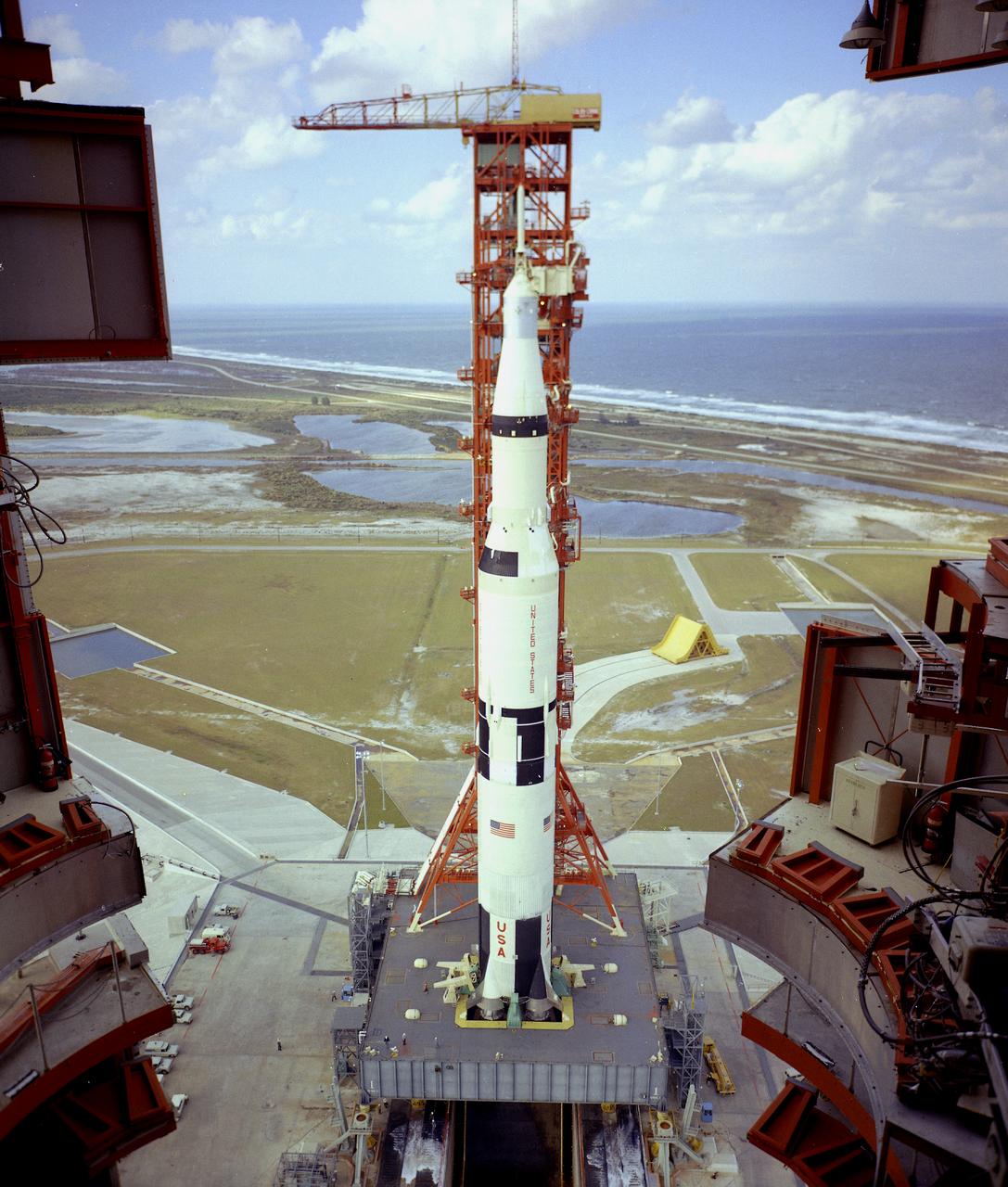 This is a view of the the first test flight of the Saturn V vehicle (SA-501) at the Kennedy Space Center (KSC) launch complex 39A. The thrust chambers of the first stage's five engines extend into the 45-foot-square hole in the mobile launcher platform. Until liftoff, the flames impinged downward onto a flame deflector that diverted the blast lengthwise in the flame trench. Here, a flame deflector, coated with a black ceramic, is in place below the opening, while a yellow (uncoated) spare deflector rests on its track in the background. It took a tremendous flow of water (28,000 gallons per minute) to cool the flame deflector and trench. The Apollo 4 was launched on November 9, 1967 from KSC. 