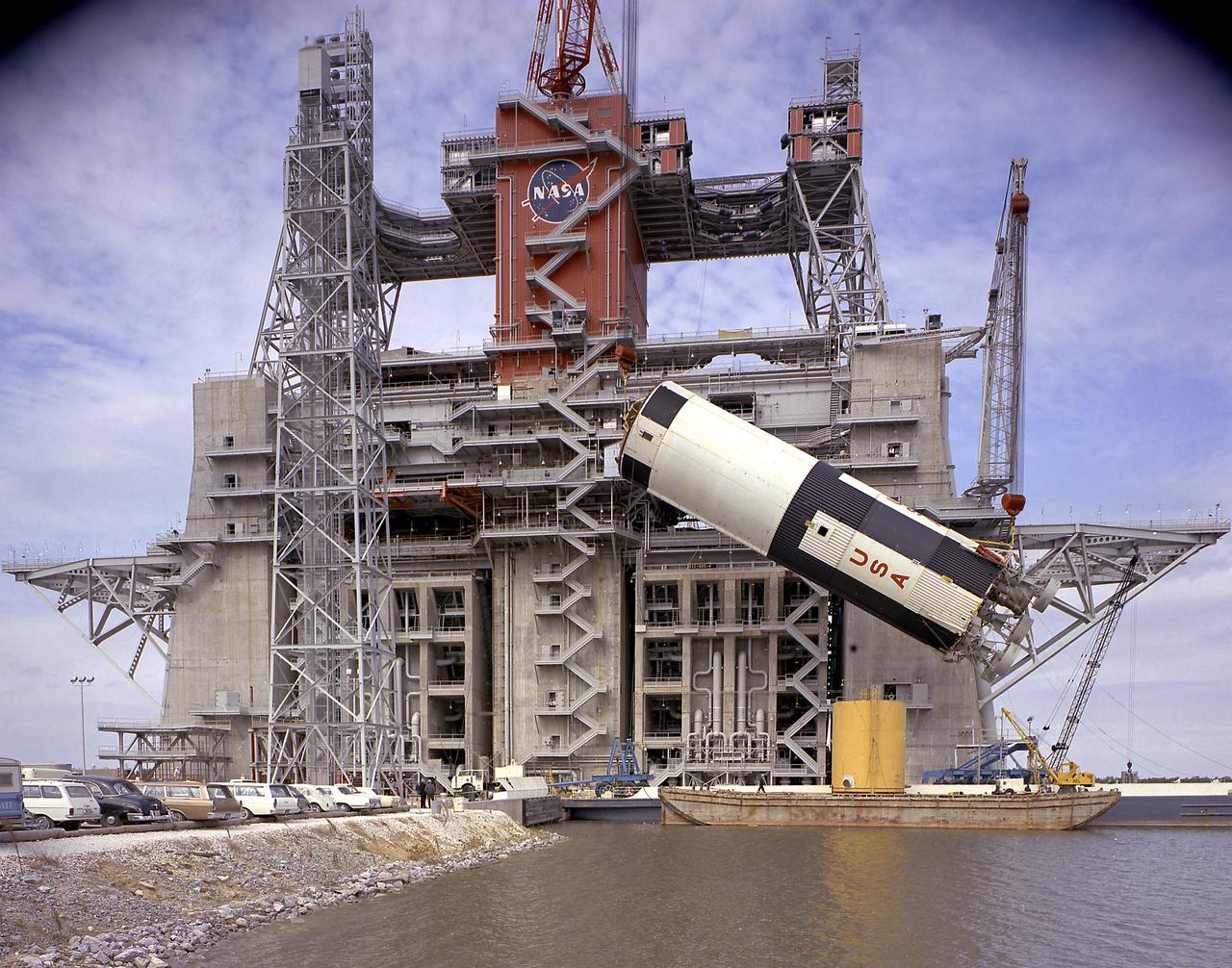 This photograph is a view of the Saturn V S-IC (first) test stage being hoisted into the S-IC-B1 test stand at the Mississippi Test Facility (MTF), Bay St. Louis, Mississippi. This stage was used to prove the operational readiness of the stand. Begirning operations in 1966, the MTF has two test stands; a dual-position structure for running the S-IC stage at full throttle, and two separate stands for the S-II (Saturn V third) stage. It became the focus of the static test firing program. The completed S-IC stage was shipped from the Michoud Assembly Facility (MAF) to the MTF. The stage was then installed into the 124-meter-high test stand for static firing tests before shipment to the Kennedy Space Center for final assembly of the Saturn V vehicle. The MTF was renamed to the National Space Technology Laboratory (NSTL) in 1974 and later to the Stennis Space Center (SSC) in May 1988. 