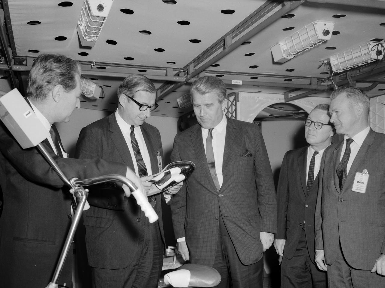 Pictured from the left, in the Saturn I mockup, are: William Brooksbank, Marshall Space Flight Center (MSFC) Propulsion and Vehicle Engineering Laboratory; Dr. Thomas O. Paine, Deputy Administrator of the National Aeronautics and Space Administration (NASA); Dr. Wernher von Braun, MSFC director; Colonel Clare F. Farley, executive officer of the Office of the Administrator; and Charles J. Donlan, newly appointed deputy associate administrator for Manned Space Flight, technical. The party examined an ordinary man’s shoe (held by Paine) outfitted for use in the Saturn I Workshop. The shoe had a unique fastener built into the sole to allow an astronaut to move about the workshop floor and to remain in one position if he desired. Dr. Paine and his party indulged in a two-day tour at the Marshall Space Flight Center getting acquainted with Marshall personnel and programs. It was Paine’s first visit to the center since assuming the NASA post on February 1, 1968.