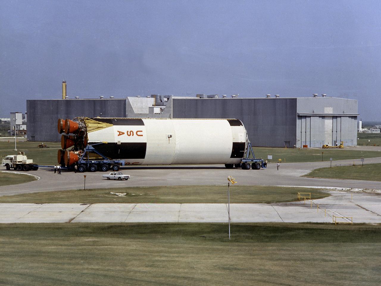 This photograph shows a completed S-IC flight stage being transferred from the vehicle assembly building to the stage test building at the Michoud Assembly Facility.