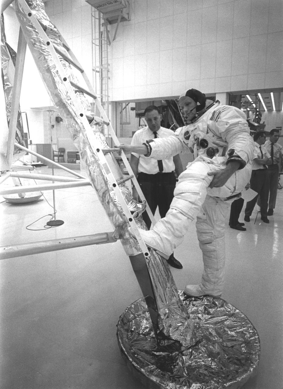 In preparation of the nation’s first Lunar landing mission, Apollo 11 crew members underwent training activities to practice activities they would be performing during the mission. In this photograph, Neil Armstrong, donned in his space suit, practices getting back to the first rung of the ladder on the Lunar Module (LM). The Apollo 11 mission launched from the Kennedy Space Center (KSC) in Florida via the Marshall Space Flight Center (MSFC) developed Saturn V launch vehicle on July 16, 1969 and safely returned to Earth on July 24, 1969. Aboard the space craft were astronauts Neil A. Armstrong, commander; Michael Collins, Command Module (CM) pilot; and Edwin E. (Buzz) Aldrin Jr., Lunar Module (LM) pilot. The CM, “Columbia”, piloted by Collins, remained in a parking orbit around the Moon while the LM, “Eagle’’, carrying astronauts Armstrong and Aldrin, landed on the Moon. On July 20, 1969, Armstrong was the first human to ever stand on the lunar surface, followed by Aldrin. During 2½ hours of surface exploration, the crew collected 47 pounds of lunar surface material for analysis back on Earth. With the success of Apollo 11, the national objective to land men on the Moon and return them safely to Earth had been accomplished.