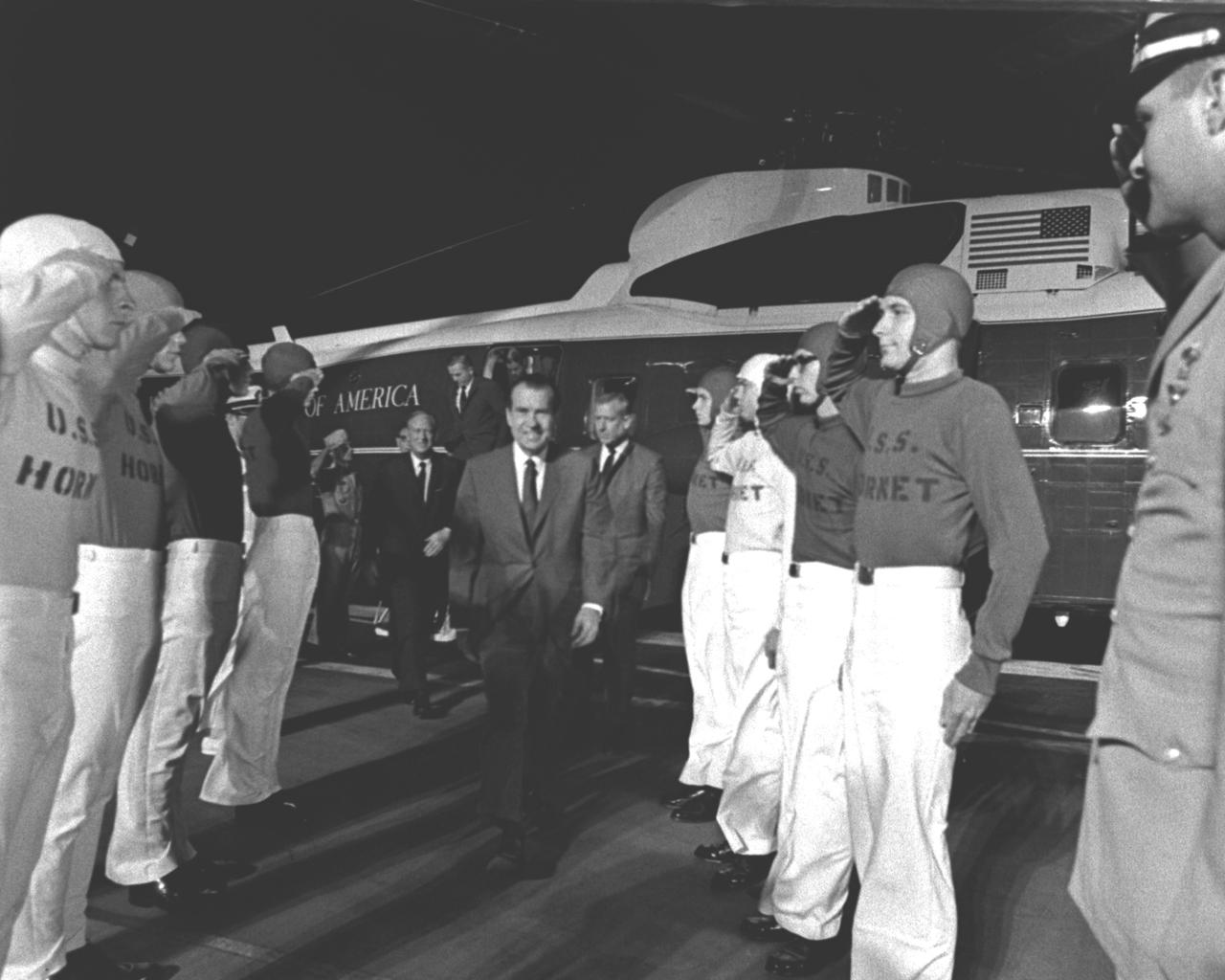 U.S. President Richard Milhous Nixon (center), is saluted by the honor guard of flight deck crewmen when he arrives aboard the U.S.S. Hornet, prime recovery ship for the Apollo 11 mission, to watch recovery operations and welcome the astronauts home. The recovery operation took place in the Pacific Ocean where Navy para-rescue men recovered the capsule housing the 3-man Apollo 11 crew. The crew was airlifted to safety aboard the U.S.S. Hornet, where they were quartered in a Mobile Quarantine Facility (MQF) for 21 days following the mission. The Apollo 11 mission, the first manned lunar mission, launched from the Kennedy Space Center, Florida via the Saturn V launch vehicle on July 16, 1969 and safely returned to Earth on July 24, 1969. Aboard were Neil A. Armstrong, commander; Michael Collins, Command Module (CM) pilot; and Edwin E. Aldrin Jr., Lunar Module (LM) pilot. The CM, piloted by Michael Collins remained in a parking orbit around the Moon while the LM, named “Eagle’’, carrying astronauts Neil Armstrong and Edwin Aldrin, landed on the Moon. Armstrong was the first human to ever stand on the lunar surface, followed by Edwin (Buzz) Aldrin.  During 2½ hours of surface exploration, the crew collected 47 pounds of lunar surface material for analysis back on Earth. With the success of Apollo 11, the national objective to land men on the Moon and return them safely to Earth had been accomplished. The Saturn V vehicle was developed by the Marshall Space Flight Center (MSFC) under the direction of Dr. Wernher von Braun.  