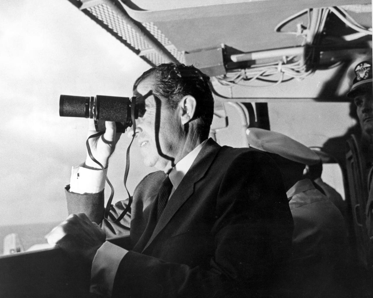 U.S. President Richard Milhous Nixon, aboard the U.S.S. Hornet aircraft carrier, used binoculars to watch the Apollo 11 Lunar Mission recovery. The recovery operation took place in the Pacific Ocean where Navy para-rescue men recovered the capsule housing the 3-man Apollo 11 crew. The crew was airlifted to safety aboard the U.S.S. Hornet, where they were quartered in a Mobile Quarantine Facility (MQF) for 21 days post mission. The Apollo 11 mission, the first manned lunar mission, launched from the Kennedy Space Center, Florida via the Saturn V launch vehicle on July 16, 1969 and safely returned to Earth on July 24, 1969. The Saturn V vehicle was developed by the Marshall Space Flight Center (MSFC) under the direction of Dr. Wernher von Braun. Aboard were Neil A. Armstrong, commander; Michael Collins, Command Module (CM) pilot; and Edwin E. Aldrin Jr., Lunar Module (LM) pilot. The CM, piloted by Michael Collins remained in a parking orbit around the Moon while the LM, named “Eagle’’, carrying astronauts Neil Armstrong and Edwin Aldrin, landed on the Moon. Armstrong was the first human to ever stand on the lunar surface, followed by Edwin (Buzz) Aldrin.  During 2½ hours of surface exploration, the crew collected 47 pounds of lunar surface material for analysis back on Earth. With the success of Apollo 11, the national objective to land men on the Moon and return them safely to Earth had been accomplished. 