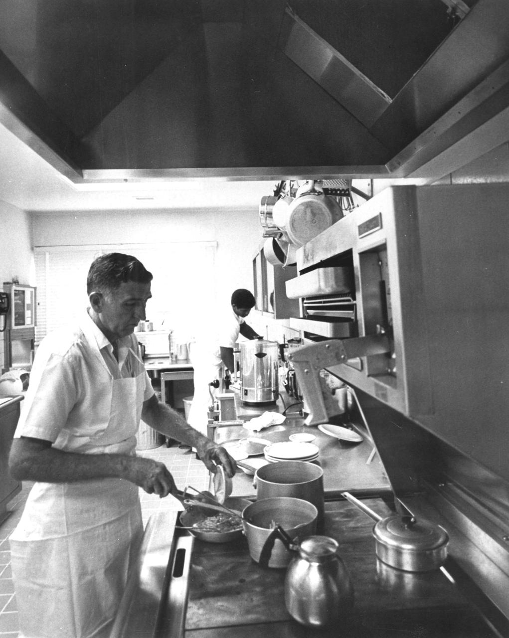 Cooks at the astronaut quarters of the NASA Kennedy Space Center (KSC) prepared meals for the Apollo 11 astronauts a few days before their historic first lunar landing mission. The Apollo 11 mission launched from KSC in Florida via the Marshall Space Flight Center (MSFC) developed Saturn V launch vehicle on July 16, 1969 and safely returned to Earth on July 24, 1969. Aboard the space craft were astronauts Neil A. Armstrong, commander; Michael Collins, Command Module (CM) pilot; and Edwin E. (Buzz) Aldrin Jr., Lunar Module (LM) pilot. The CM, “Columbia”, piloted by Collins, remained in a parking orbit around the Moon while the LM, “Eagle’’, carrying astronauts Armstrong and Aldrin, landed on the Moon. On July 20, 1969, Armstrong was the first human to ever stand on the lunar surface, followed by Aldrin. During 2½ hours of surface exploration, the crew collected 47 pounds of lunar surface material for analysis back on Earth. With the success of Apollo 11, the national objective to land men on the Moon and return them safely to Earth had been accomplished.  
