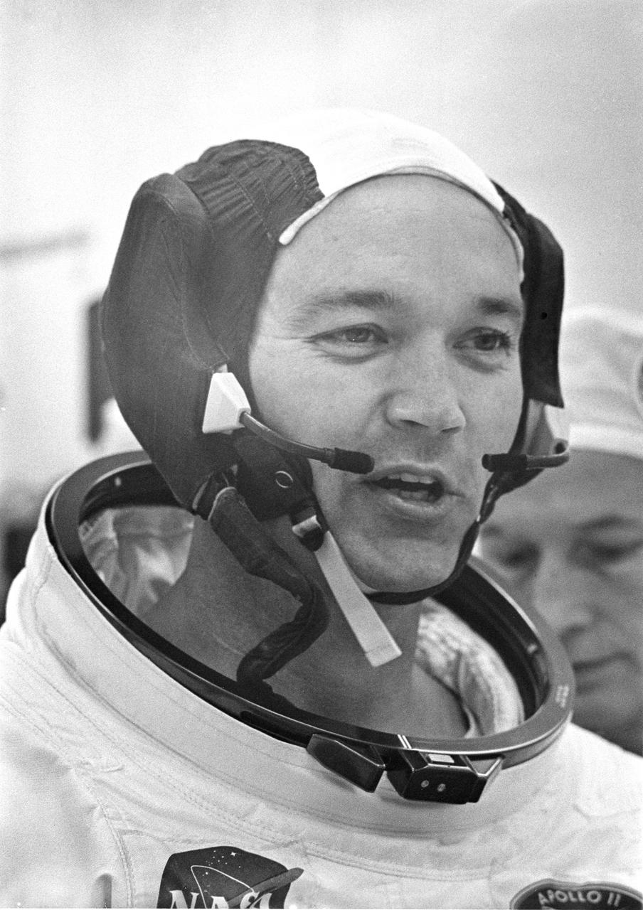 Dunned in his space suit, Command Module (CM) pilot Michael Collins does a final check of his communications system before the boarding of the Apollo 11 mission. Launched via a Saturn V launch vehicle, the first manned lunar mission launched from the Kennedy Space Center, Florida on July 16, 1969 and safely returned to Earth on July 24, 1969. The Saturn V vehicle was developed by the Marshall Space Flight Center (MSFC) under the direction of Dr. Wernher von Braun. The 3-man crew aboard the flight consisted of astronauts Collins; Neil A.  Armstrong, Mission Commander; and Edwin E. Aldrin, Jr., Lunar Module (LM) Pilot.  Armstrong was the first human to ever stand on the lunar surface, followed by Edwin (Buzz) Aldrin. Meanwhile, astronaut Collins piloted the CM in a parking orbit around the Moon. During a 2½ hour surface exploration, the crew collected 47 pounds of lunar surface material which was returned to Earth for analysis. With the success of Apollo 11, the national objective to land men on the Moon and return them safely to Earth had been accomplished. 