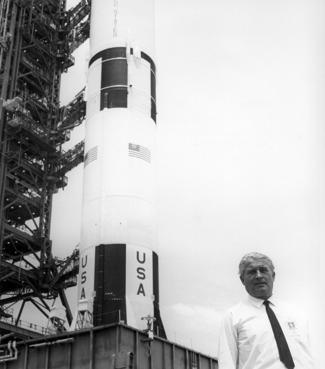 Dr. Wernher von Braun, director of the NASA Marshall Space Flight center (MSFC), talks with news reporters while paused in front of the mobile launcher and base of the Saturn V rocket (AS-506) being readied for the historic Apollo 11 lunar landing mission at the Kennedy Space Center (KSC). The Saturn V vehicle was developed by MSFC under the direction of Dr. von Braun. The Apollo 11 mission launched from the KSC in Florida via the MSFC developed Saturn V launch vehicle on July 16, 1969 and safely returned to Earth on July 24, 1969. Aboard the space craft were astronauts Neil A. Armstrong, commander; Michael Collins, Command Module (CM) pilot; and Edwin E. (Buzz) Aldrin Jr., Lunar Module (LM) pilot. The CM, “Columbia”, piloted by Collins, remained in a parking orbit around the Moon while the LM, “Eagle’’, carrying astronauts Armstrong and Aldrin, landed on the Moon. On July 20, 1969, Armstrong was the first human to ever stand on the lunar surface, followed by Aldrin. During 2½ hours of surface exploration, the crew collected 47 pounds of lunar surface material for analysis back on Earth. With the success of Apollo 11, the national objective to land men on the Moon and return them safely to Earth had been accomplished. 