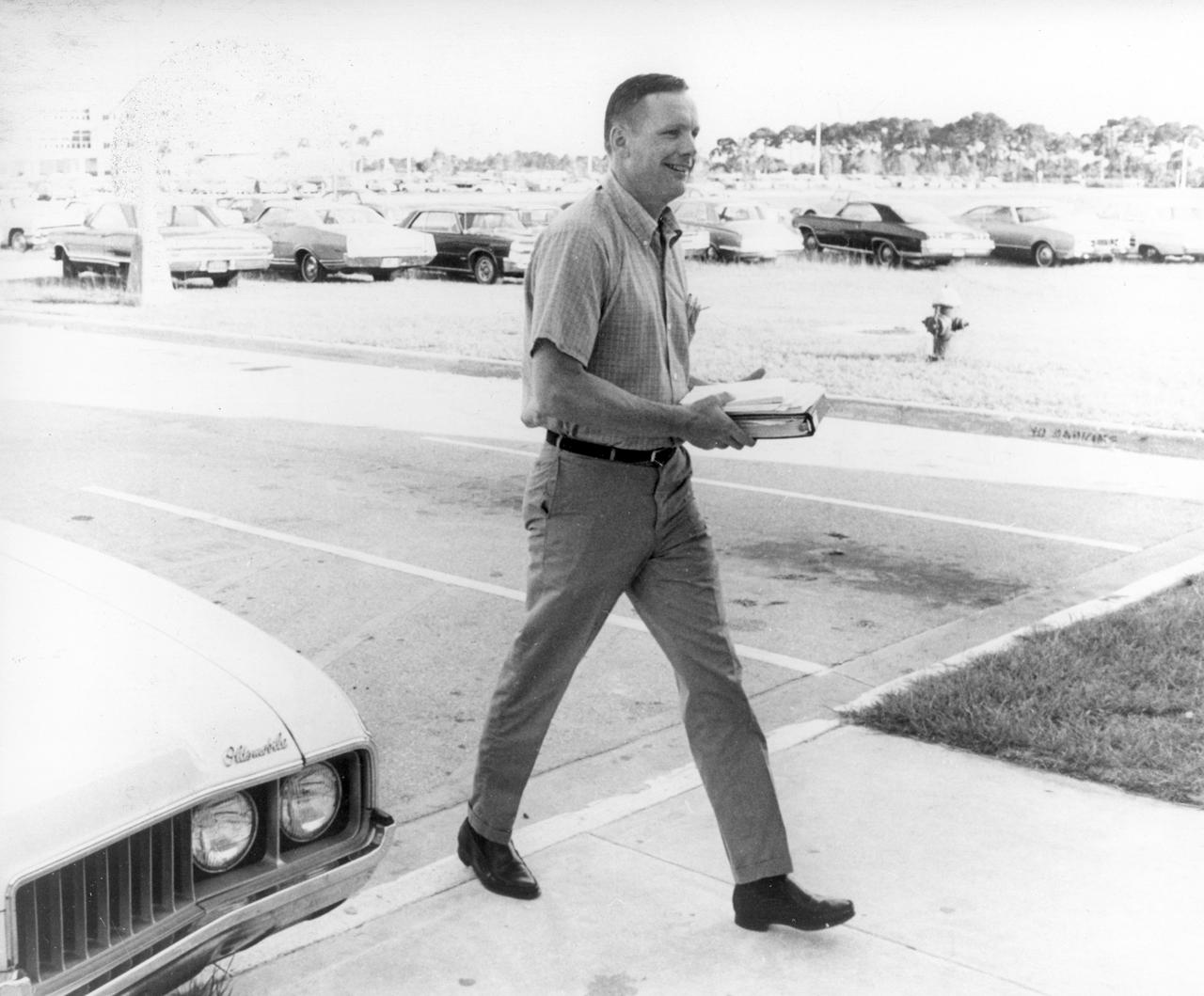 In this photograph, Apollo 11 astronaut  Neil Armstrong walks to the flight crew training building at the NASA Kennedy Space Center (KSC) in Florida, one week before the nation’s first lunar landing mission. The Apollo 11 mission launched from KSC via the Marshall Space Flight Center (MSFC) developed Saturn V launch vehicle on July 16, 1969 and safely returned to Earth on July 24, 1969. Aboard the space craft were astronauts Neil A. Armstrong, commander; Michael Collins, Command Module (CM) pilot; and Edwin E. (Buzz) Aldrin Jr., Lunar Module (LM) pilot. The CM, “Columbia”, piloted by Collins, remained in a parking orbit around the Moon while the LM, “Eagle’’, carrying astronauts Armstrong and Aldrin, landed on the Moon. On July 20, 1969, Armstrong was the first human to ever stand on the lunar surface, followed by Aldrin. During 2½ hours of surface exploration, the crew collected 47 pounds of lunar surface material for analysis back on Earth. With the success of Apollo 11, the national objective to land men on the Moon and return them safely to Earth had been accomplished. 