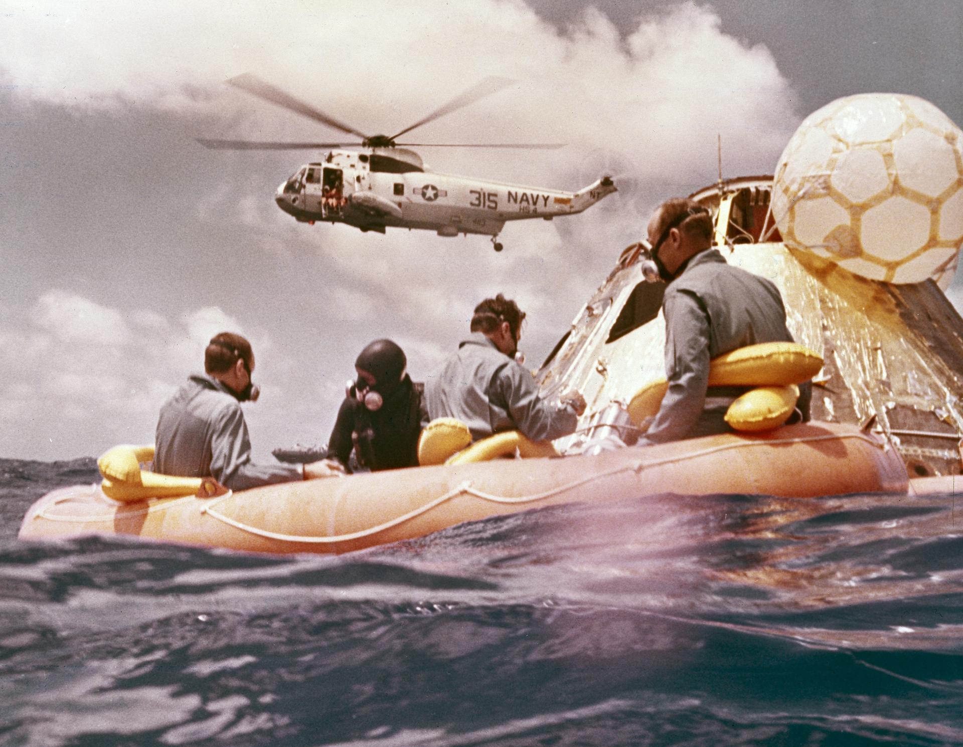 The Apollo 12 crew sits in a raft after splashdown of their spacecraft.