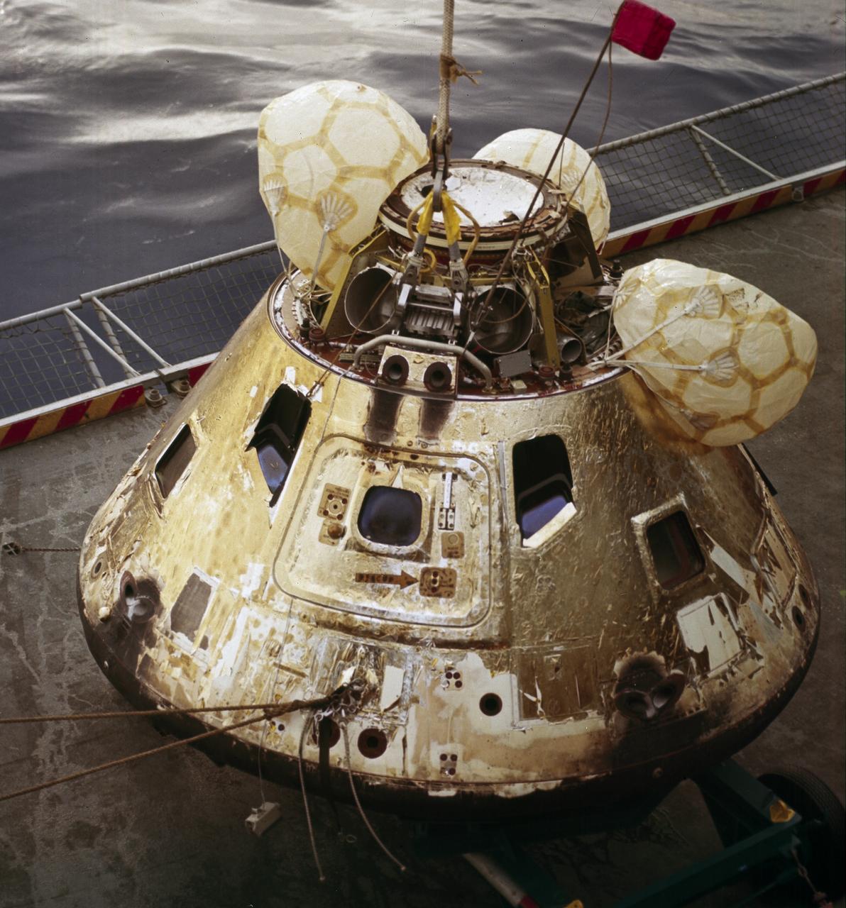 This is a photograph of the Apollo 8 Capsule being hoisted onto the recovery ship following splashdown on December 27, 1968. The first manned Apollo mission to escape Earth’s gravity and travel to the lunar vicinity, the Saturn V, SA-503, Apollo 8 mission liftoff occurred seven days prior, on December 21, 1968. Aboard were astronauts William Anders, Lunar Module (LM) Pilot; James Lovell, Command Module (CM) pilot; and Frank Borman, commander. The mission achieved operational experience and tested the Apollo command module systems, including communications, tracking, and life-support, in cis-lunar space and lunar orbit, and allowed evaluation of crew performance on a lunar orbiting mission. The crew photographed the lunar surface, both far side and near side, obtaining information on topography and landmarks as well as other scientific information necessary for future Apollo landings. All systems operated within allowable parameters and all objectives of the mission were achieved.
