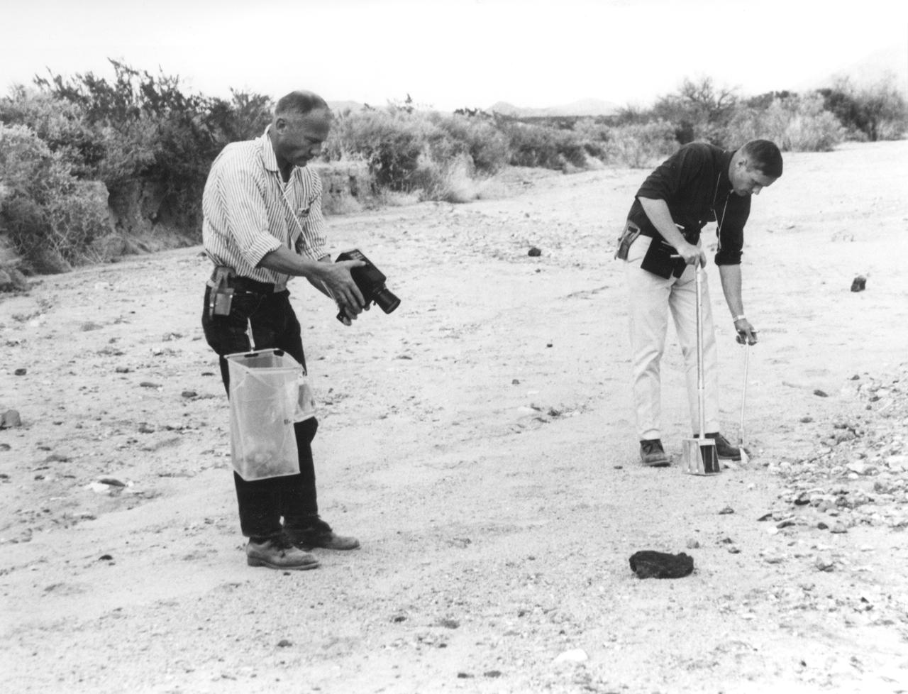 In this photograph, Apollo 11 astronauts Edwin (Buzz) Aldrin (left) and Neil A. Armstrong prepare for the first Lunar landing as they practice gathering rock specimens during a geological field trip to the Quitman Mountains area near the Fort Quitman ruins in far west Texas. They used special lunar geological tools to pick up samples and place them in bags.Their practice paid off in July of the same year. Aboard the Marshall Space Fight center (MSFC) developed Saturn V launch vehicle, the Apollo 11 mission launched from the Kennedy Space Center, Florida on July 16, 1969 and safely returned to Earth on July 24, 1969. The 3-man crew aboard the flight consisted of Armstrong, commander; Aldrin, Lunar Module pilot; and a third astronaut Michael Collins, Command Module pilot. Armstrong was the first human to ever stand on the lunar surface, followed by Aldrin, while Collins remained in lunar orbit. The crew collected 47 pounds of lunar surface material which was returned to Earth for analysis. The lunar surface exploration was concluded in 2½ hours. 