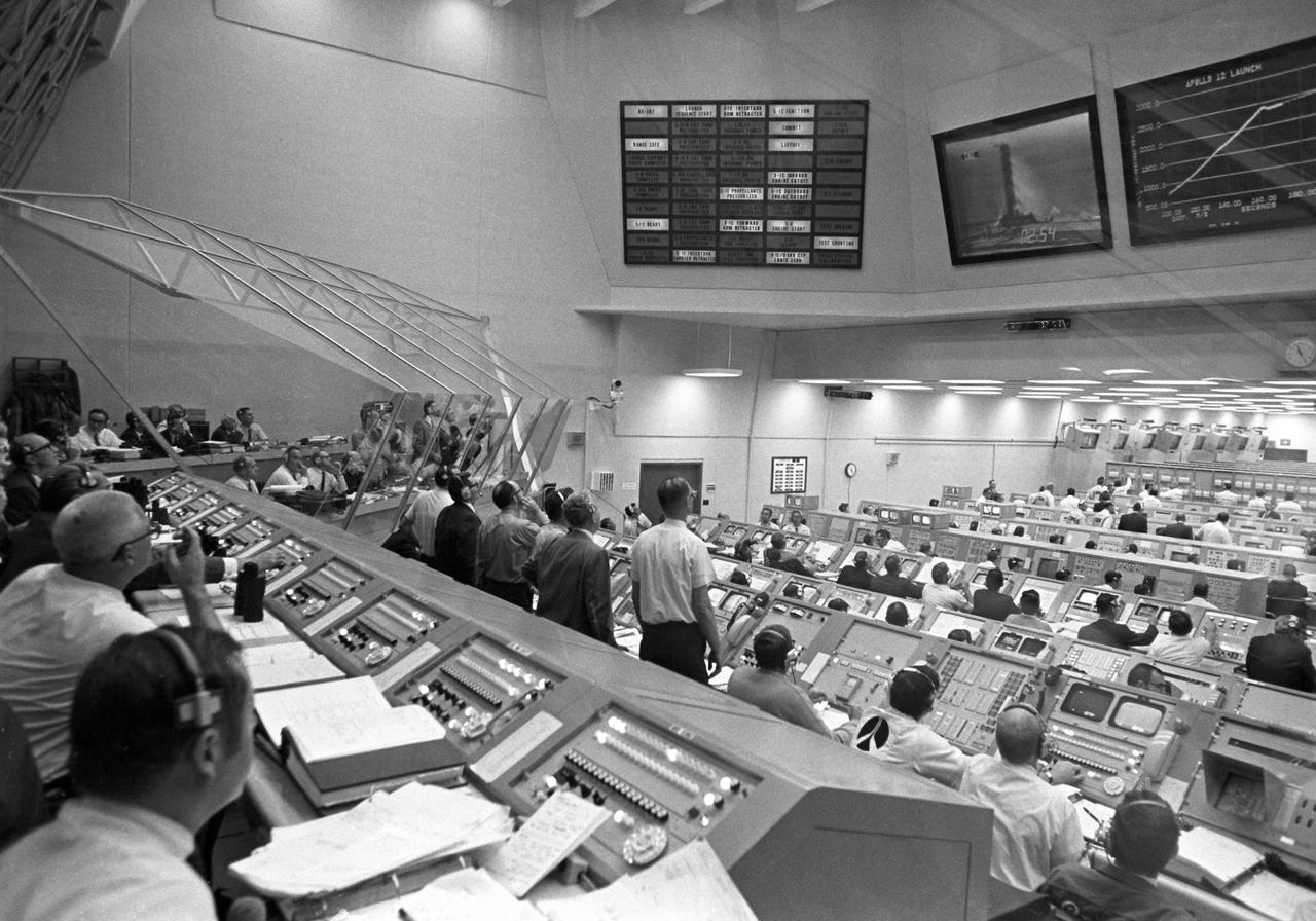CAPE CANAVERAL, Fla. -- Personnel within Firing Room 2 of the LCC follow the early moments of the Apollo 12 launch on their overhead data display boards.  When this view was taken, the vehicle’s second stage engines had ignited, carrying the Apollo 12 spacecraft to an altitude of more than 229,000 feet and more that 50 miles downrange.   Photo credit: NASA
