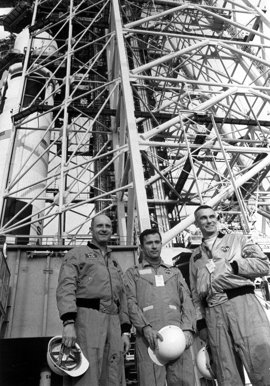 KENNEDY SPACE CENTER, FLA. -- The May 18 launch date for the Apollo 10 mission is now little more than a month away for its prime crew, shown here at Complex 39's Pad B.  From left are Thomas P. Stafford, commander; John W. Young, command module pilot; and Eugene A. Cernan, lunar module pilot.  Visible through the girders of the Mobile Service Structure is the launch vehicle which will hurl them toward the Moon in a mission that is to carry Stafford and Cernan to within 50,000 feet of the lunar surface.