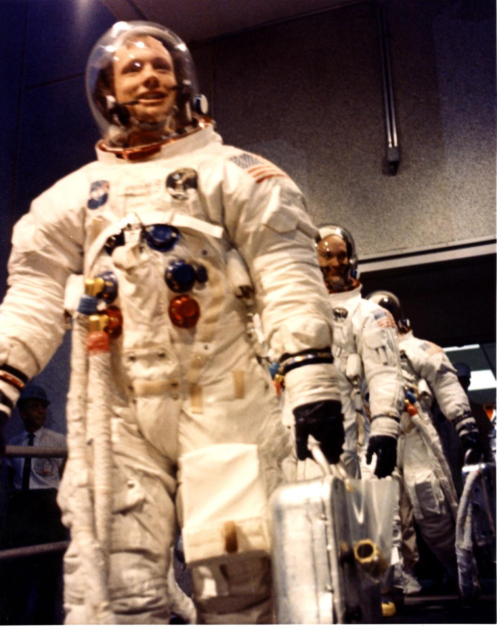 KENNEDY SPACE CENTER, FLA. -  Apollo 11 Commander Neil A. Armstrong leads astronauts Michael Collins and Edwin E. Aldrin Jr. from the Manned Spacecraft Operations Building to the transfer van for the eight-mile trip to Pad 39A.  Liftoff of Apollo 11 is scheduled at 9:32 a.m. EDT, which will begin man's first lunar landing mission.