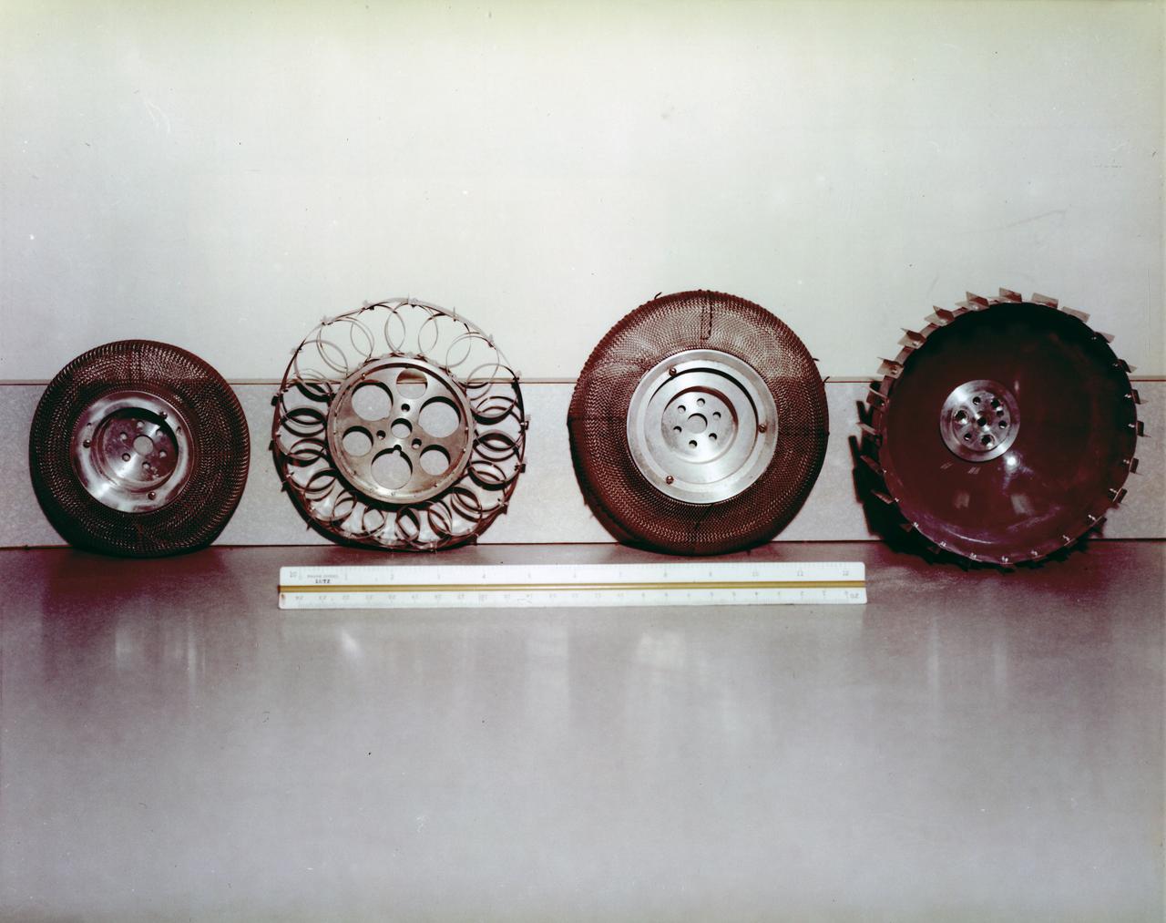 Under the direction of Marshall Space Flight Center (MSFC), the Lunar Roving Vehicle (LRV)  was designed to allow Apollo astronauts a greater range of mobility during lunar exploration missions. During the development process, LRV prototype wheels underwent soil tests in building 4481 at Marshall Space Flight Center (MSFC). Pictured from left to right are the wheels for: LRV, Bendix Corporation, Local Scientific Survey Module (LSSM), and Grumman Industries.