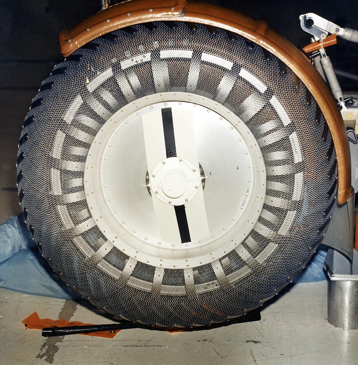 This is a close-up view of a left front wheel of the Lunar Roving Vehicle (LRV) No. 1. The LRV was built to give Apollo astronauts a greater range of mobility during lunar exploration. It was an open-space and collapsible vehicle about 10 feet long with large mesh wheels, anterna, appendages, tool caddies, and camera. An LRV was used on each of the last three Apollo missions; Apollo 15, Apollo 16, and Apollo 17. It was built by the Boeing Company under the direction of the Marshall Space Flight Center.