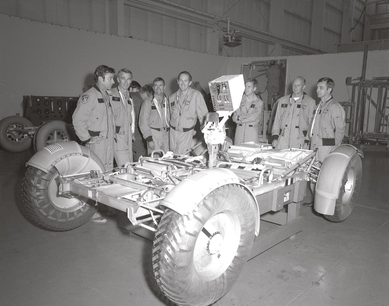 In this November 1971 photograph, (from left to right) Astronauts John Young, Eugene Cernan, Charles Duke, Fred Haise, Anthony England, Charles Fullerton, and Donald Peterson await deployment tests of the Lunar Roving Vehicle (LRV) qualification test unit in building 4649 at the Marshall Space Flight Center (MSFC). The LRV, developed under the direction of the MSFC, was designed to allow Apollo astronauts a greater range of mobility on the lunar surface during the last three lunar exploration missions; Apollo 15, Apollo 16, and Apollo 17.