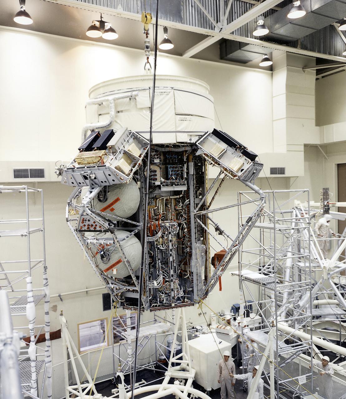 This photograph depicts the flight article of the Airlock Module (AM) Flight Article being mated to the Fixed Airlock Shroud and aligned in a clean room of the McDornell Douglas Plant in St. Louis, Missouri. The AM enabled crew members to conduct extravehicular activities outside Skylab as required for experiment support. Separated from the Workshop and the Multiple Docking Adapter by doors, the AM could be evacuated for egress or ingress of a space-suited astronaut through a side hatch. Oxygen and nitrogen storage tanks needed for Skylab's life support system were mounted on the external truss work of the AM. Major components in the AM included Skylab's electric power control and distribution station, environmental control system, communication system, and data handling and recording systems. The Marshall Space Flight Center was responsible for the design and development of the Skylab hardware and experiment management. 