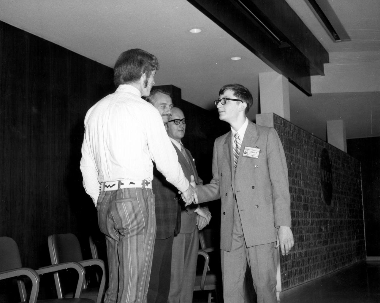 Youngstown, Ohio high school student, W. Brian Dunlap, is greeted by (left to right): Astronauts Russell L. Schweickart, and Owen K. Garriott; Marshall Space Flight Center (MSFC) Skylab Program Manager, Leland Belew; and MSFC Director of Administration and Technical Services, David Newby, during a tour of MSFC. Dunlap was among 25 winners of a contest in which some 3,500 high school students proposed experiments for the following year’s Skylab mission. The nationwide scientific competition was sponsored by the National Science Teachers Association and the National Aeronautics and Space Administration (NASA). The winning students, along with their parents and sponsor teachers, visited MSFC where they met with scientists and engineers, participated in design reviews for their experiments, and toured MSFC facilities. Of the 25 students, 6 did not see their experiments conducted on Skylab because the experiments were not compatible with Skylab hardware and timelines. Of the 19 remaining, 11 experiments required the manufacture of additional equipment. 