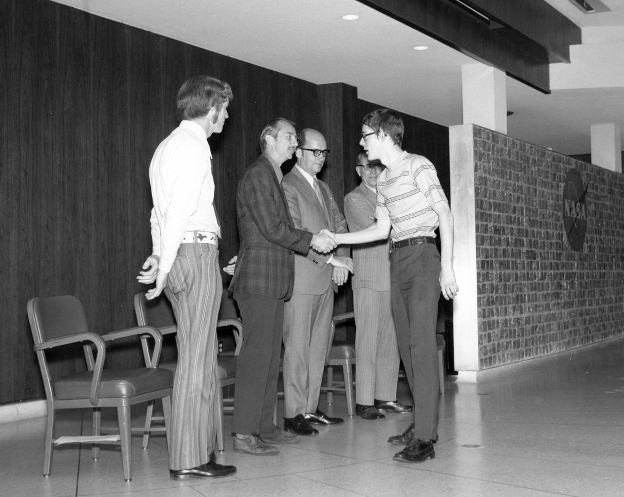 St. Paul, Minnesota high school student, Roger Johnston, is greeted by (left to right): Astronauts Russell L. Schweickart, and Owen K. Garriott; Marshall Space Flight Center (MSFC) Skylab Program Manager, Leland Belew; and MSFC Director of Administration and Technical Services, David Newby, during a tour of MSFC.  Johnston was among 25 winners of a contest in which some 3,500 high school students proposed experiments for the following year’s Skylab mission. The nationwide scientific competition was sponsored by the National Science Teachers Association and the National Aeronautics and Space Administration (NASA). The winning students, along with their parents and sponsor teachers, visited MSFC where they met with scientists and engineers, participated in design reviews for their experiments, and toured MSFC facilities. Of the 25 students, 6 did not see their experiments conducted on Skylab because the experiments were not compatible with Skylab hardware and timelines. Of the 19 remaining, 11 experiments required the manufacture of additional equipment. 