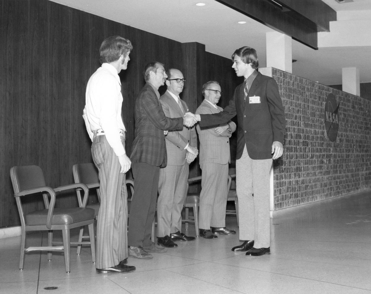 Garland, Texas high school student, Keith D. McGee, is greeted by (left to right): Astronauts Russell L. Schweickart, and Owen K. Garriott; Marshall Space Flight Center (MSFC) Skylab Program Manager, Leland Belew; and MSFC Director of Administration and Technical Services, David Newby, during a tour of MSFC. McGee was among 25 winners of a contest in which some 3,500 high school students proposed experiments for the following year’s Skylab Mission. The nationwide scientific competition was sponsored by the National Science Teachers Association and the National Aeronautics and Space Administration (NASA). The winning students, along with their parents and sponsor teachers, visited MSFC where they met with scientists and engineers, participated in design reviews for their experiments, and toured MSFC facilities. Of the 25 students, 6 did not see their experiments conducted on Skylab because the experiments were not compatible with Skylab hardware and timelines. Of the 19 remaining, 11 experiments required the manufacture of additional equipment. 