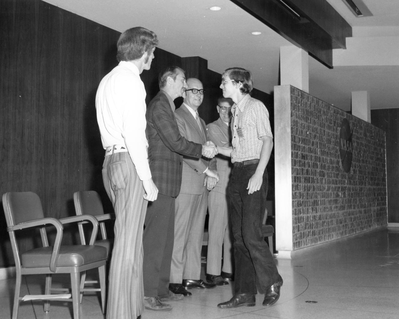 Downey, California high school student, Donald W. Shellack, is greeted by (left to right): Astronauts Russell L. Schweickart, and Owen K. Garriott; Marshall Space Flight Center (MSFC) Skylab Program Manager, Leland Belew; and MSFC Director of Administration and Technical Services, David Newby, during a tour of MSFC. Shellack was among 25 winners of a contest in which some 3,500 high school students proposed experiments for the following year’s Skylab mission. The nationwide scientific competition was sponsored by the National Science Teachers Association and the National Aeronautics and Space Administration (NASA). The winning students, along with their parents and sponsor teachers, visited MSFC where they met with scientists and engineers, participated in design reviews for their experiments, and toured MSFC facilities. Of the 25 students, 6 did not see their experiments conducted on Skylab because the experiments were not compatible with Skylab hardware and timelines. Of the 19 remaining, 11 experiments required the manufacture of additional equipment. 