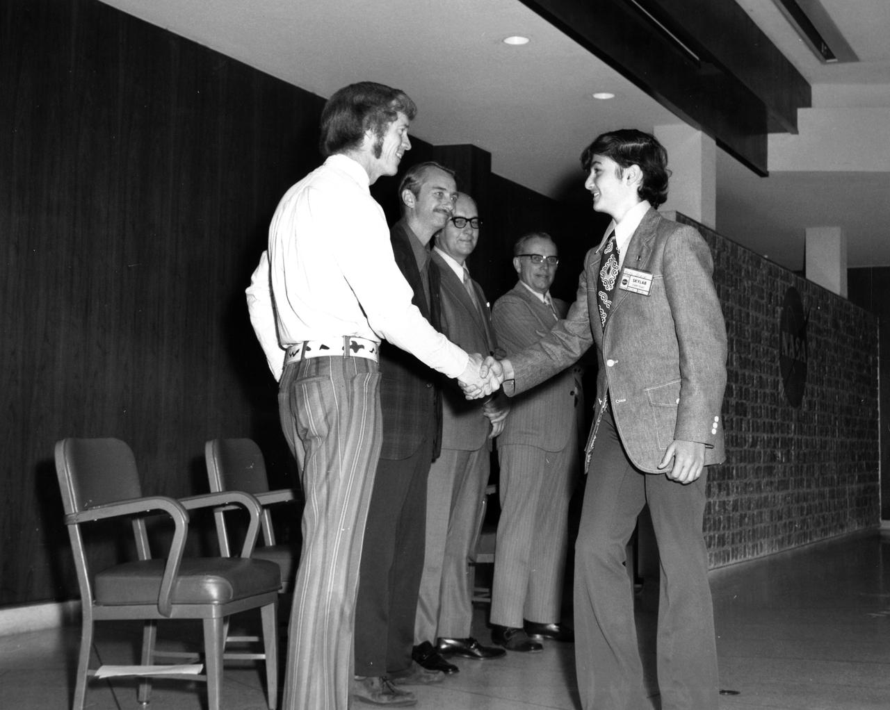 Westbury, New York high school student, Keith L.Stein , is greeted by (left to right): Astronauts Russell L. Schweickart, and Owen K. Garriott; Marshall Space Flight Center (MSFC) Skylab Program Manager, Leland Belew; and MSFC Director of Administration and Technical Services, David Newby, during a tour of MSFC. Stein was among 25 winners of a contest in which some 3,500 high school students proposed experiments for the following year’s Skylab mission. The nationwide scientific competition was sponsored by the National Science Teachers Association and the National Aeronautics and Space Administration (NASA). The winning students, along with their parents and sponsor teachers, visited MSFC where they met with scientists and engineers, participated in design reviews for their experiments, and toured MSFC facilities. Of the 25 students, 6 did not see their experiments conducted on Skylab because the experiments were not compatible with Skylab hardware and timelines. Of the 19 remaining, 11 experiments required the manufacture of additional equipment. 