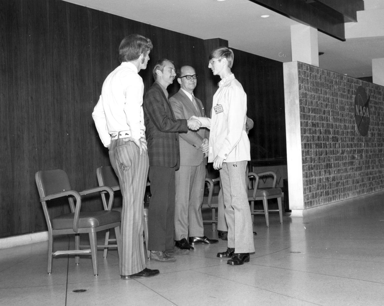West Point, Nebraska high school student, Joel C. Wordekemper, is greeted by (left to right): Astronauts Russell L. Schweickart, and Owen K. Garriott; Marshall Space Flight Center (MSFC) Skylab Program Manager, Leland Belew; and MSFC Director of Administration and Technical Services, David Newby, during a tour of MSFC. Wordekemper was among 25 winners of a contest in which some 3,500 high school students proposed experiments for the following year’s Skylab mission. The nationwide scientific competition was sponsored by the National Science Teachers Association and the National Aeronautics and Space Administration (NASA). The winning students, along with their parents and sponsor teachers, visited MSFC where they met with scientists and engineers, participated in design reviews for their experiments, and toured MSFC facilities. Of the 25 students, 6 did not see their experiments conducted on Skylab because the experiments were not compatible with Skylab hardware and timelines. Of the 19 remaining, 11 experiments required the manufacture of additional equipment. 