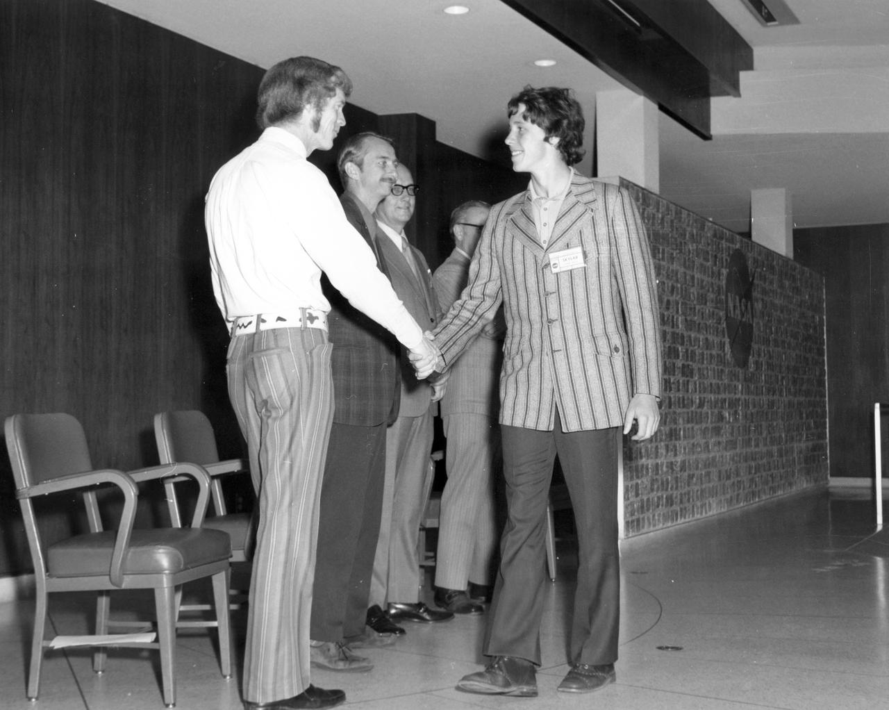Oshkosh, Wisconsin high school student, Joe B. Zmolek, is greeted by (left to right): Astronauts Russell L. Schweickart, and Owen K. Garriott; Marshall Space Flight Center (MSFC) Skylab Program Manager, Leland Belew; and MSFC Director of Administration and Technical Services, David Newby, during a tour of MSFC. Zmolek was among 25 winners of a contest in which some 3,500 high school students proposed experiments for the following year’s Skylab mission. The nationwide scientific competition was sponsored by the National Science Teachers Association and the National Aeronautics and Space Administration (NASA). The winning students, along with their parents and sponsor teachers, visited MSFC where they met with scientists and engineers, participated in design reviews for their experiments, and toured MSFC facilities. Of the 25 students, 6 did not see their experiments conducted on Skylab because the experiments were not compatible with Skylab hardware and timelines. Of the 19 remaining, 11 experiments required the manufacture of additional equipment. 
